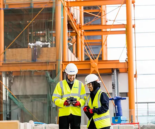 Two colleagues using technology on site